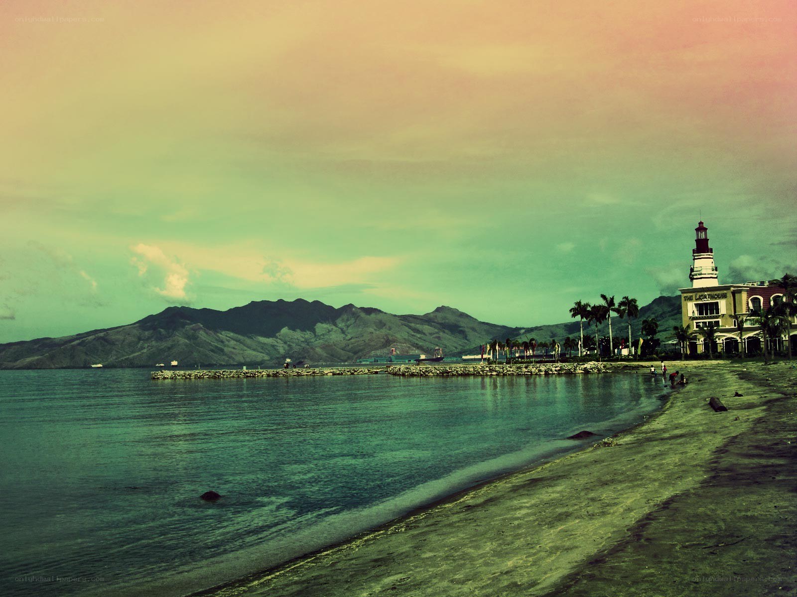 Beach with lighthouse and mountains