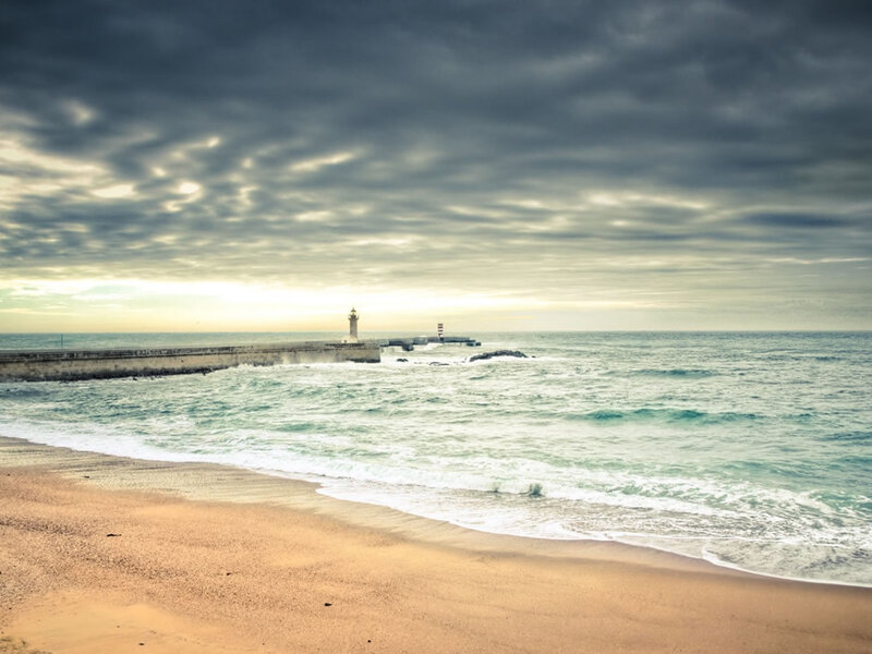 Beach with lighthouse at sunset