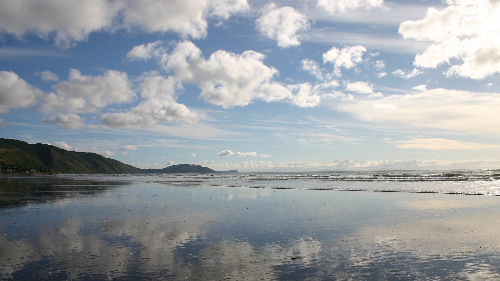 beach with mountains and clouds