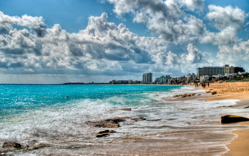 Beach with Ocean Waves — Blue, Dramatic, Afternoon, Photograph, Clouds, Buildings