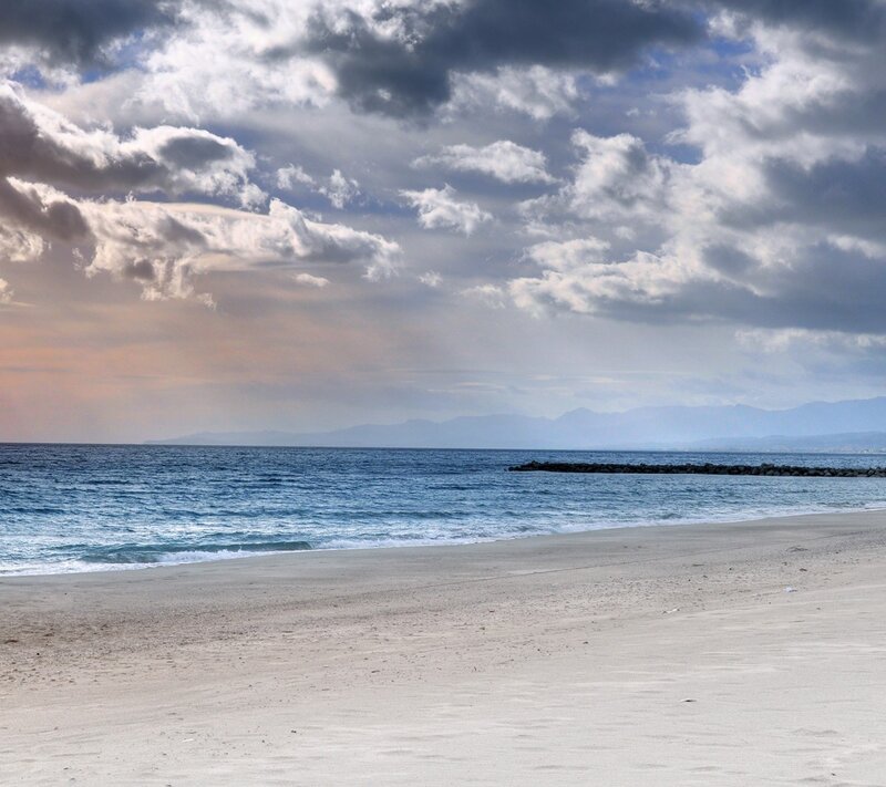 Beach with Ocean Waves — Blue, Dramatic, Afternoon, Photograph, Clouds, Mountains, Breakwater