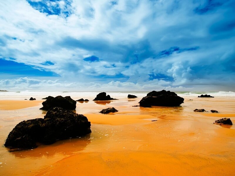 beach with orange sand and rocks