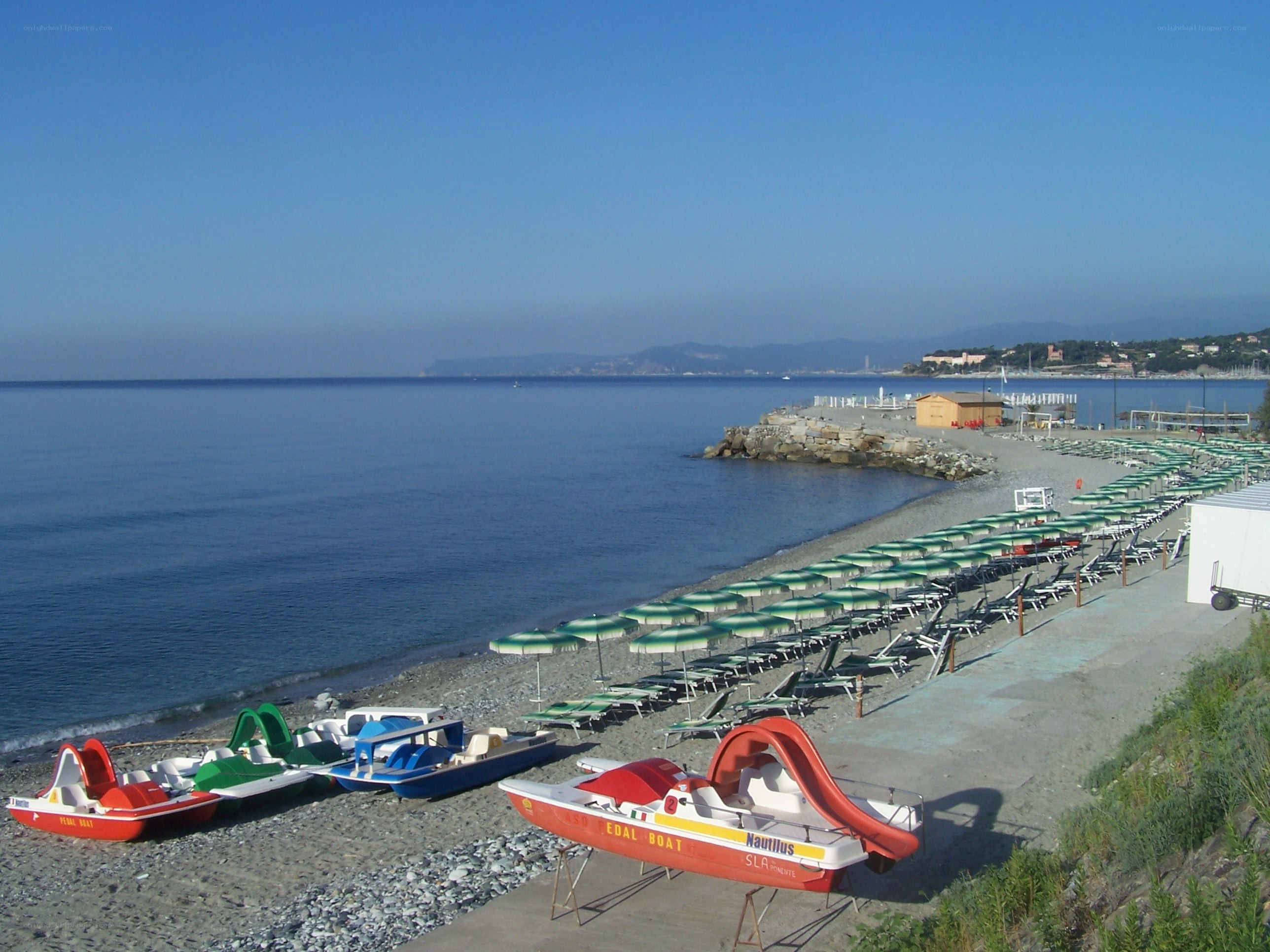 Beach with pedal boats and umbrellas
