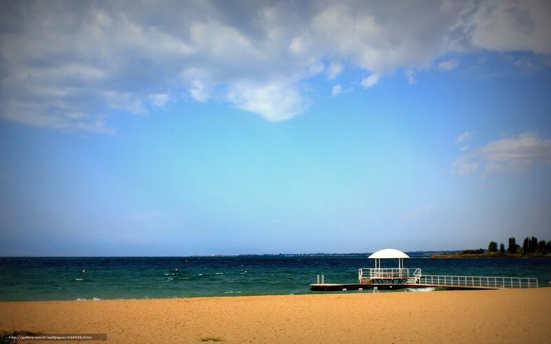Beach with pier and cloudy sky