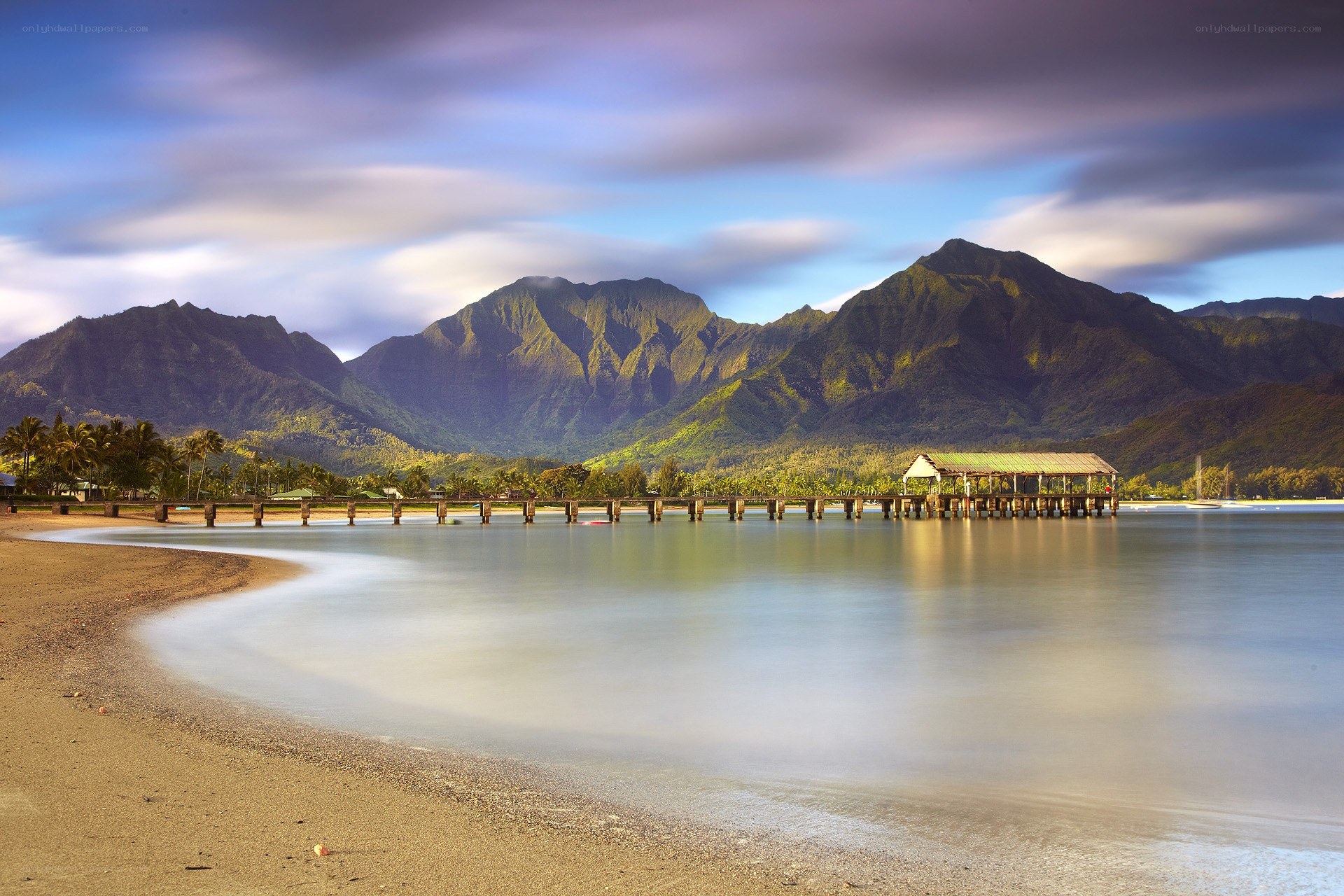 beach with pier and mountains