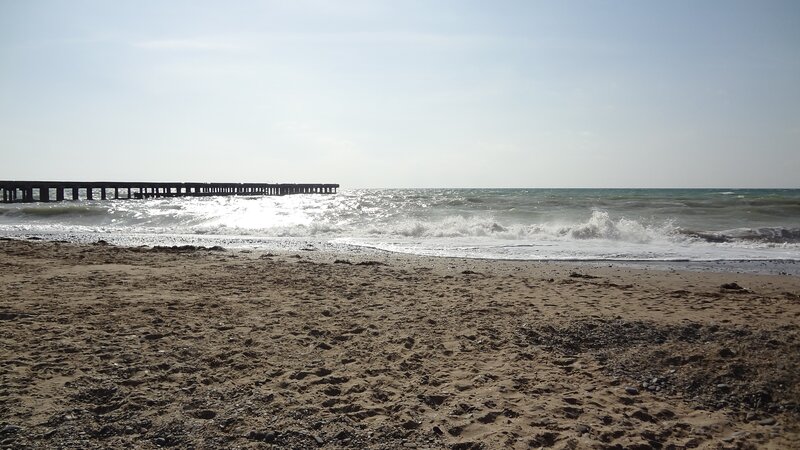 Beach with pier and waves