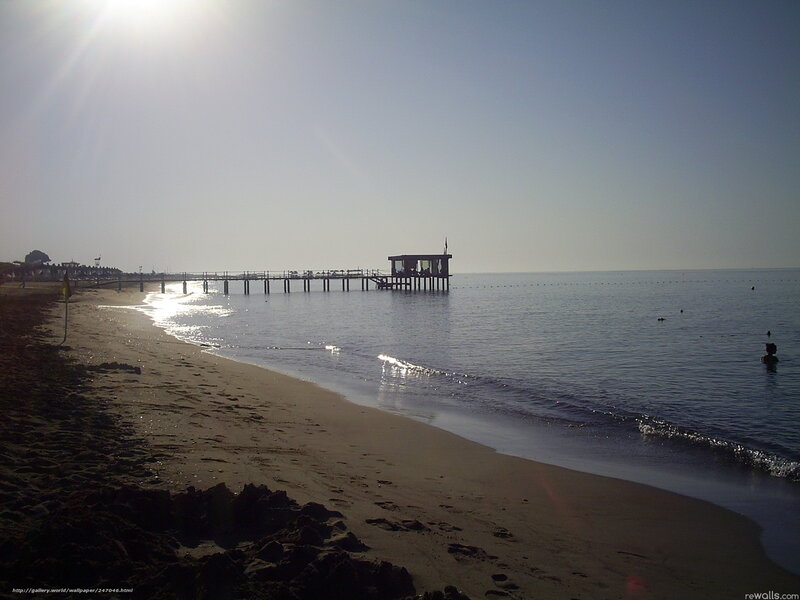 Beach with pier at sunset