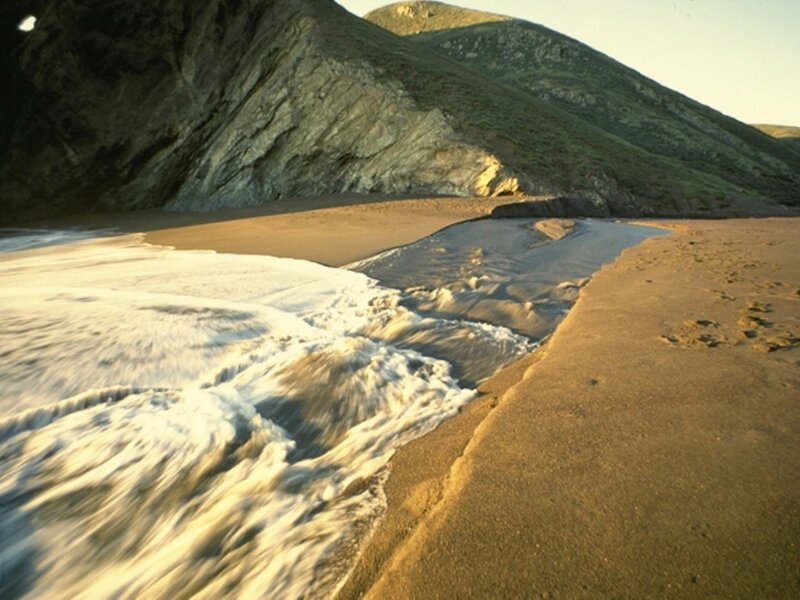 beach with river and cliffs