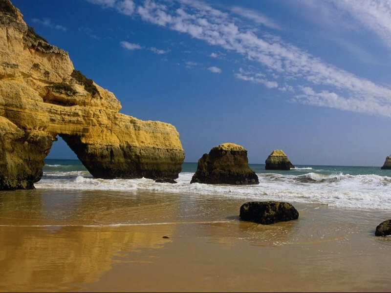 beach with rock arch and sea stacks