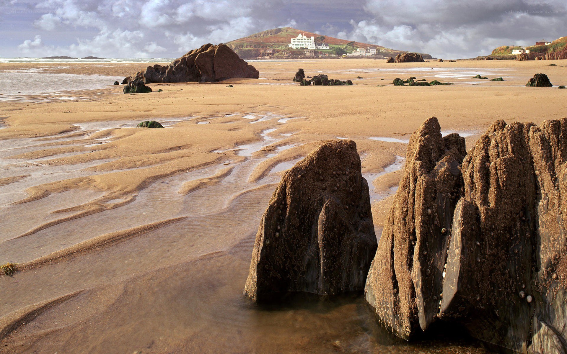 beach with rocks and distant buildings