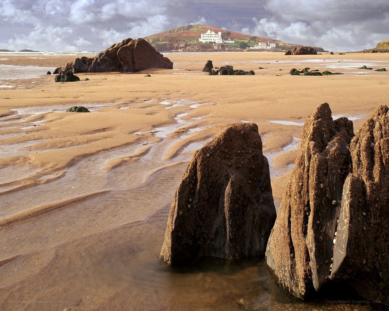 beach with rocks and distant buildings