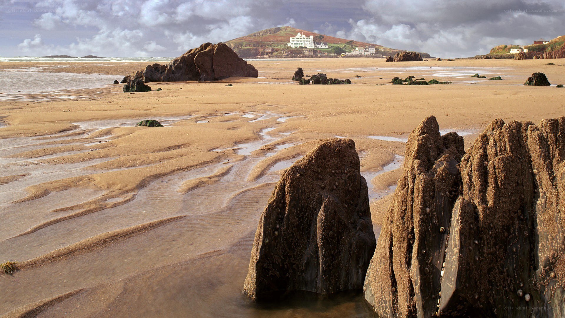 beach with rocks and distant buildings