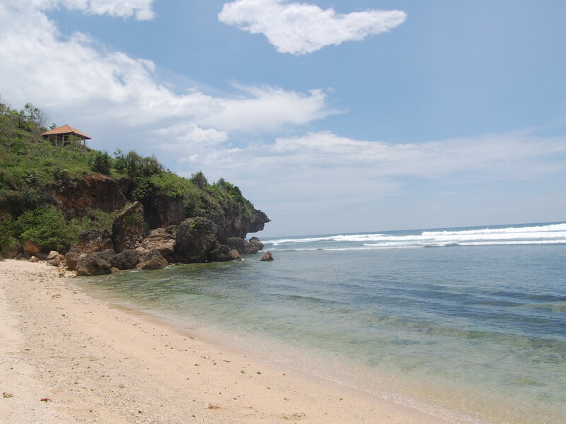 beach with rocky cliff and gazebo