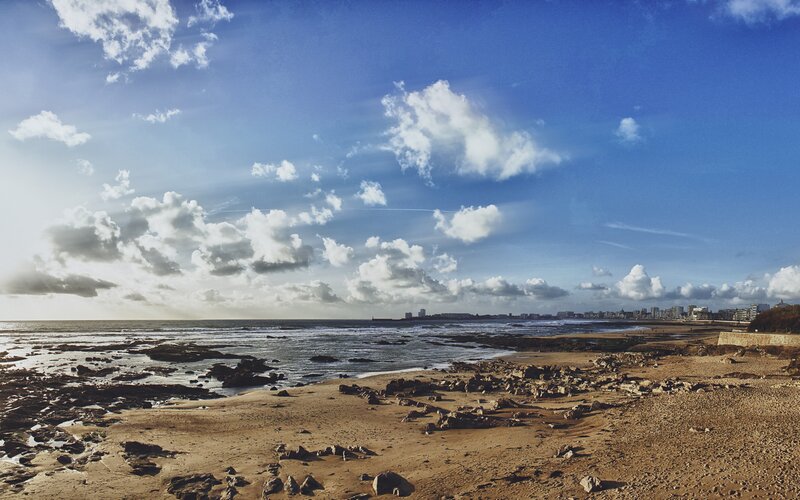 Beach with rocky shore and city skyline