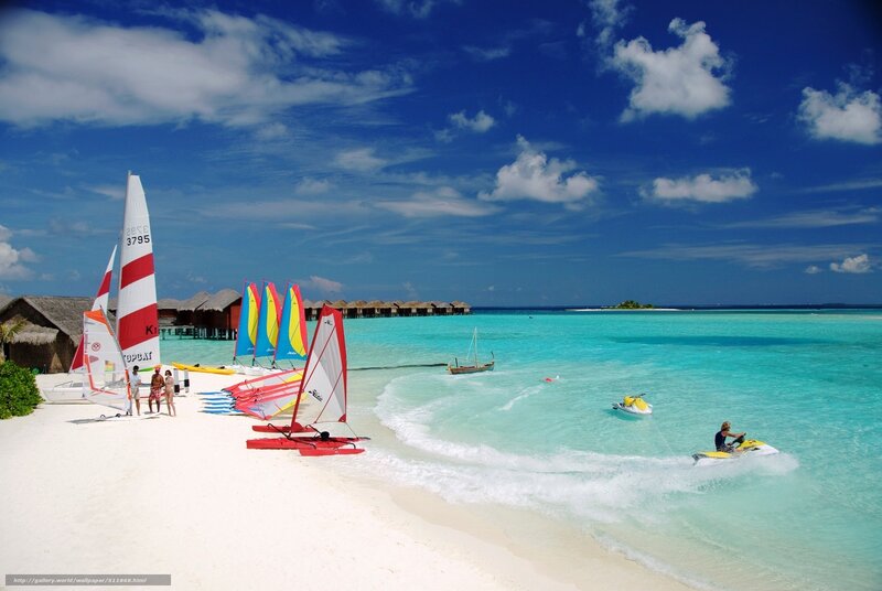 Beach with sailboats and jet skis