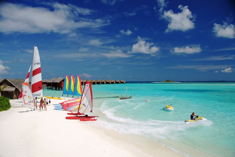 Beach with sailboats and jet skis