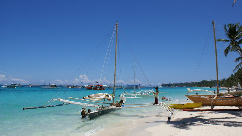 Beach with sailboats and people