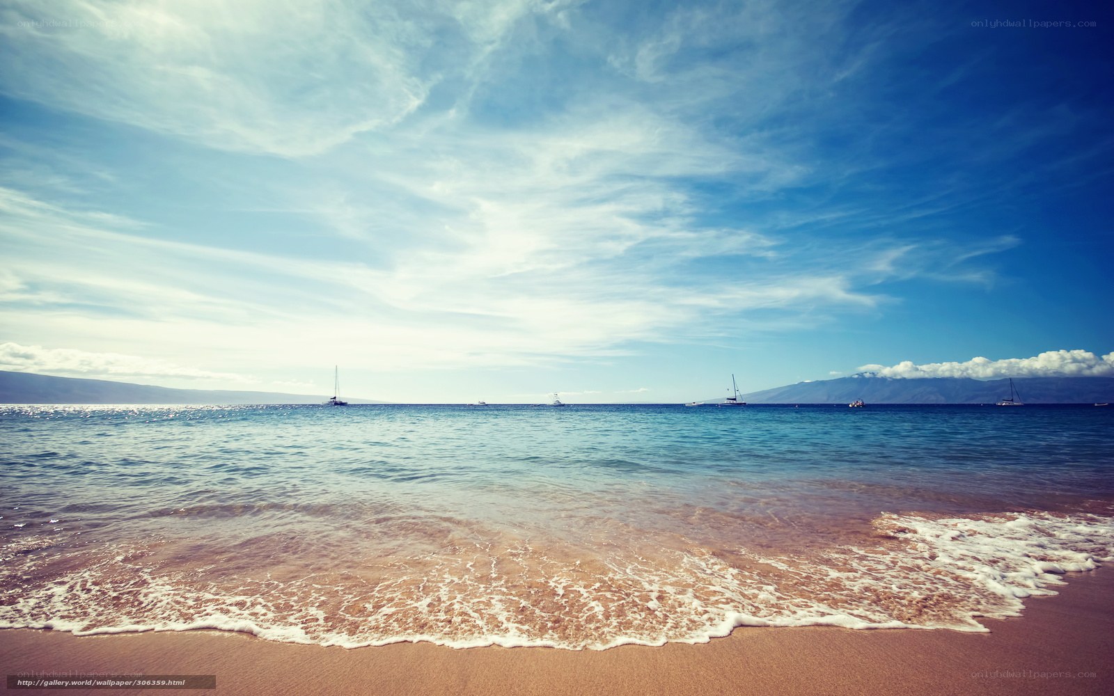 Beach with sailboats at sunset