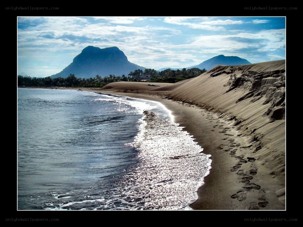 beach with sand dunes and mountains