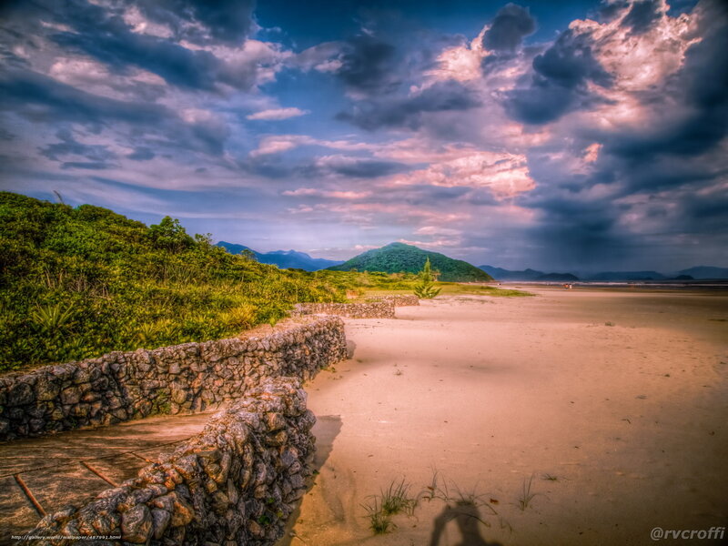 Beach with stone wall and dramatic sky
