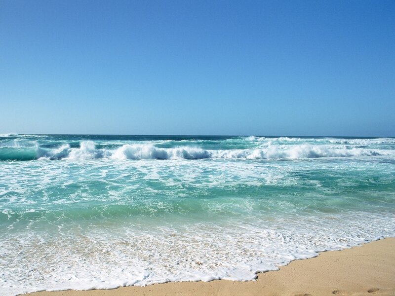 beach with waves and blue sky