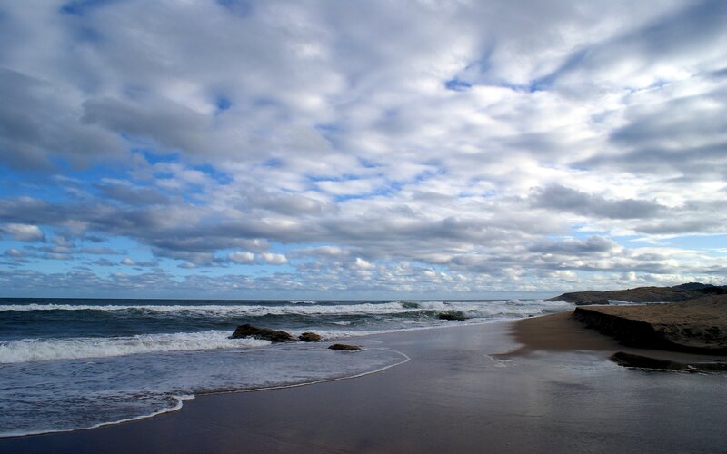 beach with waves and cloudy sky