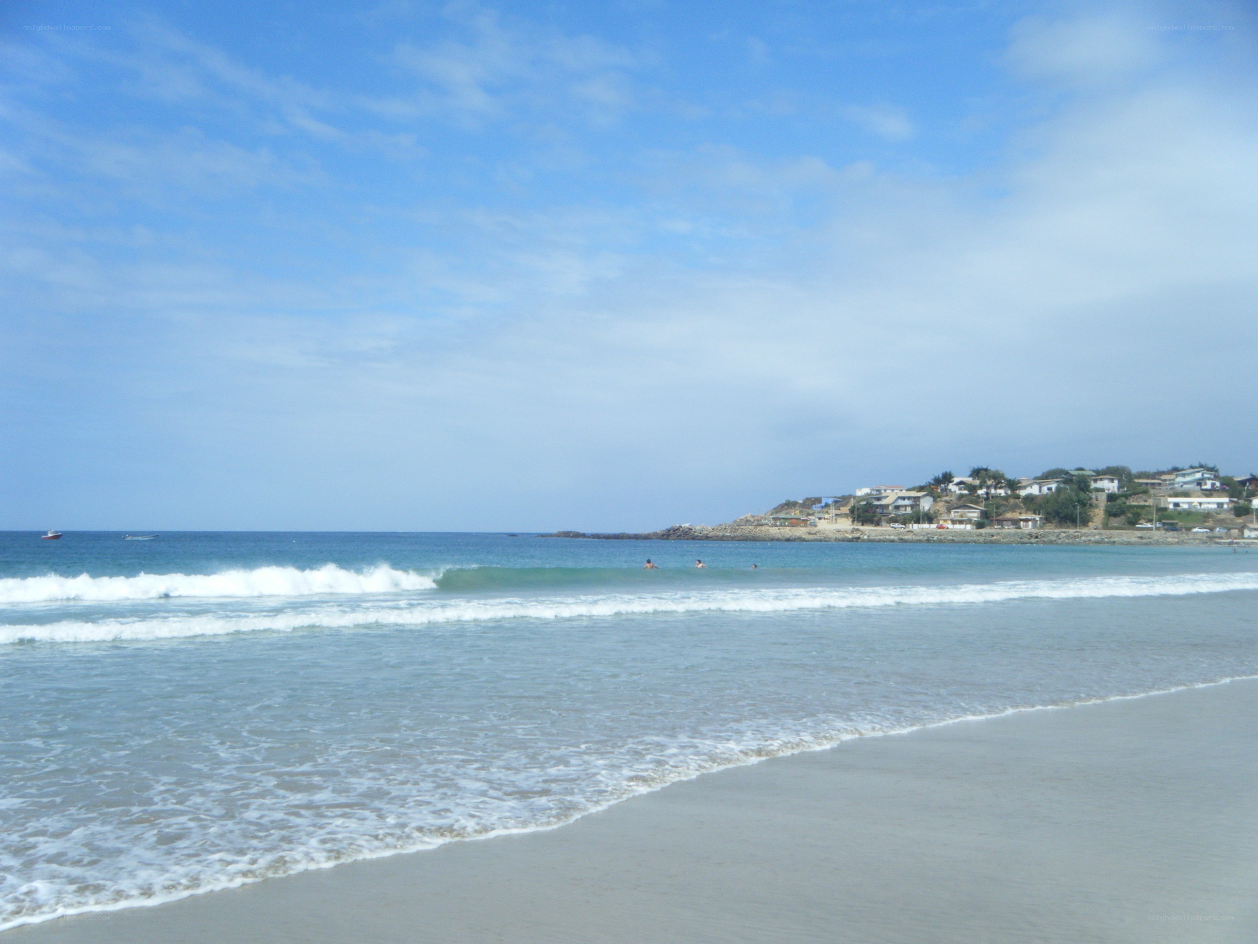 beach with waves and houses