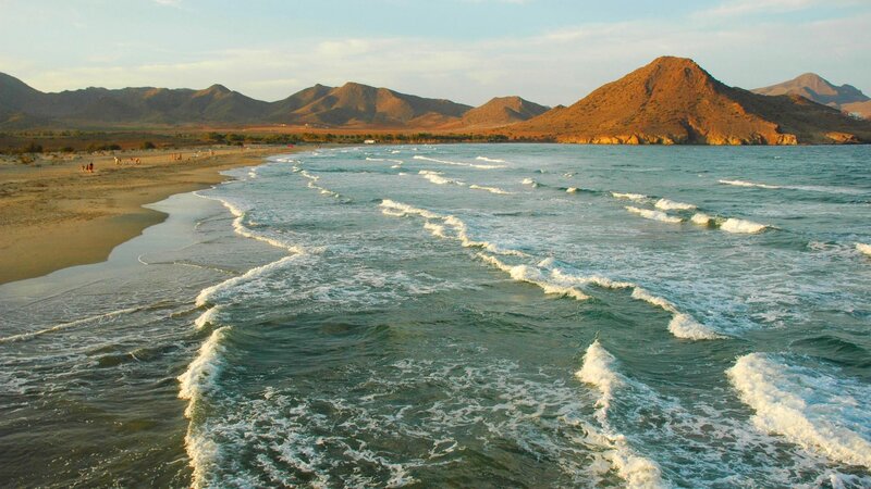 beach with waves and mountains