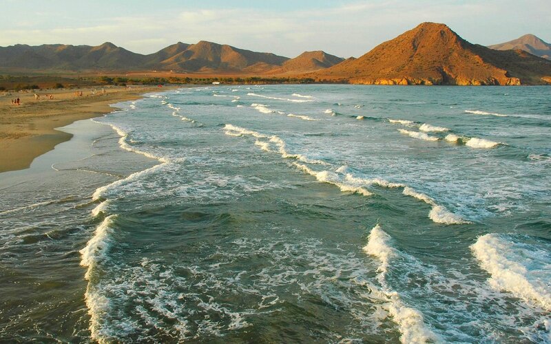 beach with waves and mountains