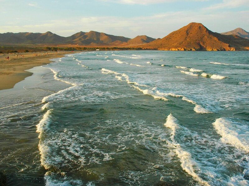beach with waves and mountains