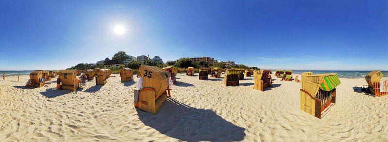 Beach with wicker chairs on a sunny day