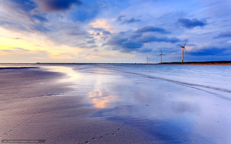 Beach with wind turbines at sunset