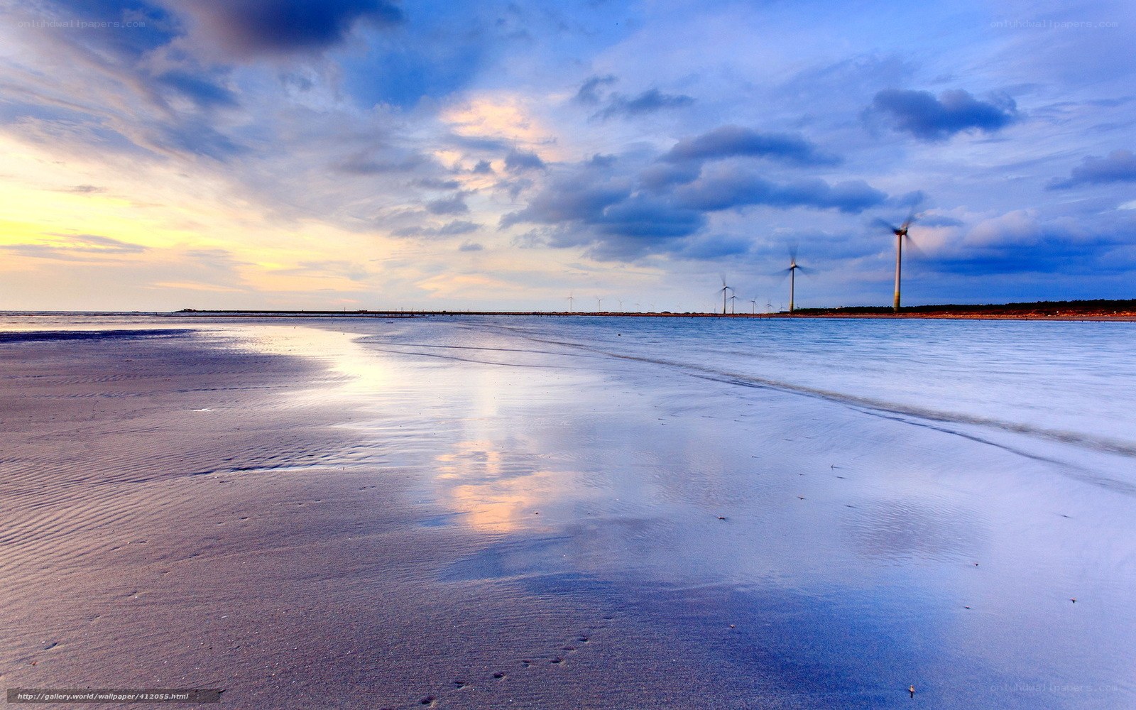 Beach with wind turbines at sunset