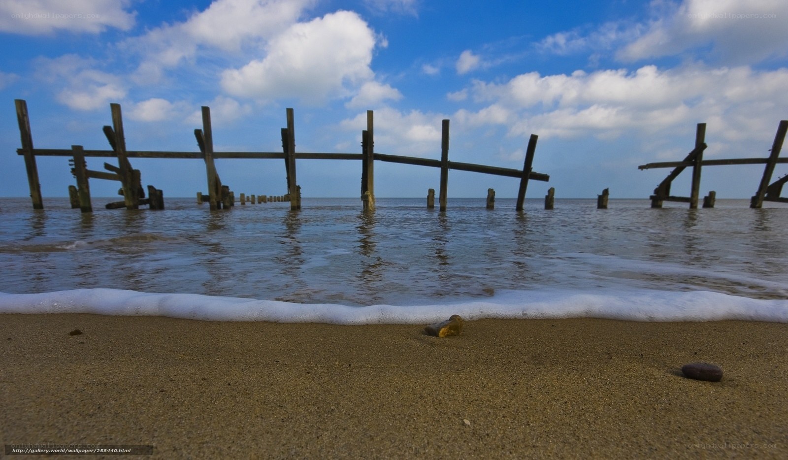 Beach with wooden pier ruins