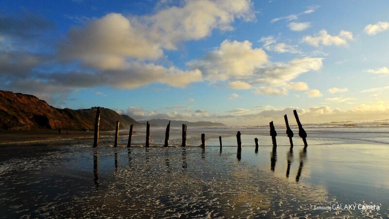 Beach with wooden posts at sunset