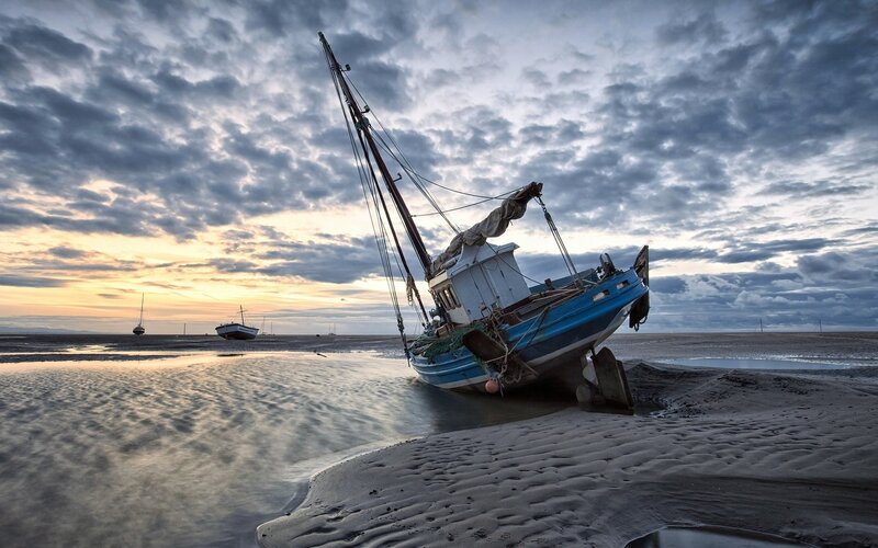Beached fishing boat at sunset
