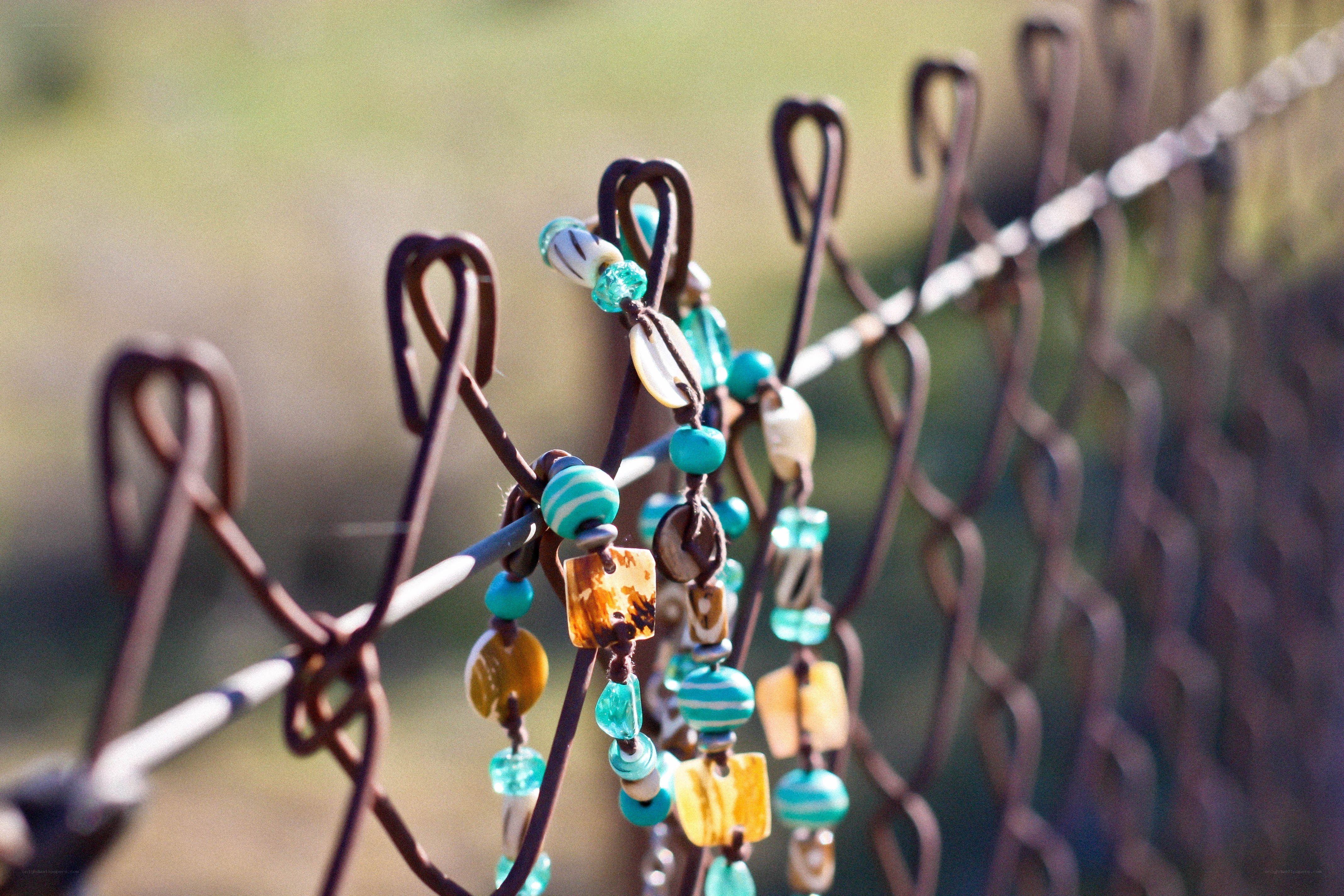 Beaded necklaces on a fence