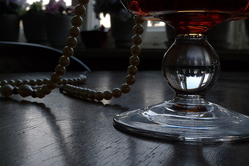 beads and glass on dark wood