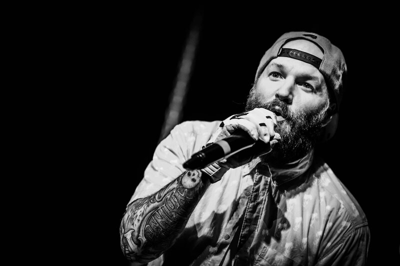 bearded man singing into microphone