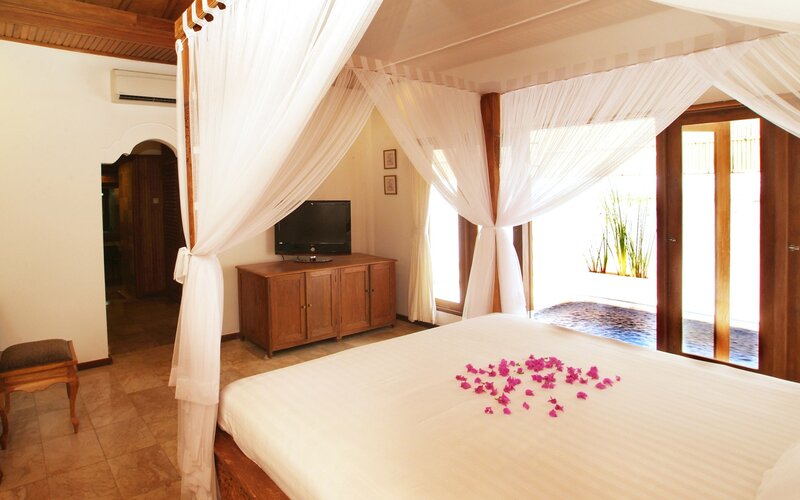 Bed with flower petals in a tropical room