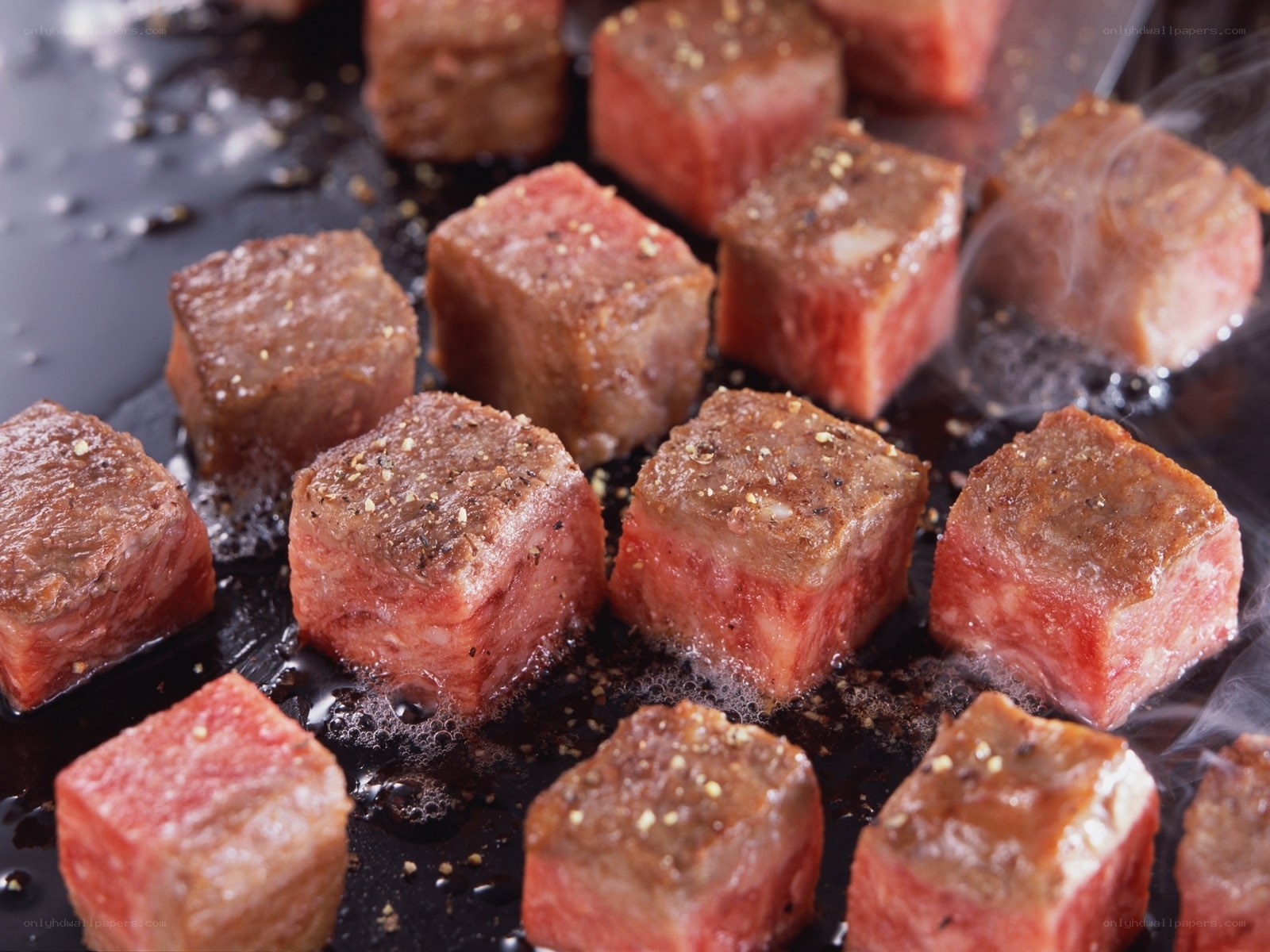 Beef cubes cooking on a griddle