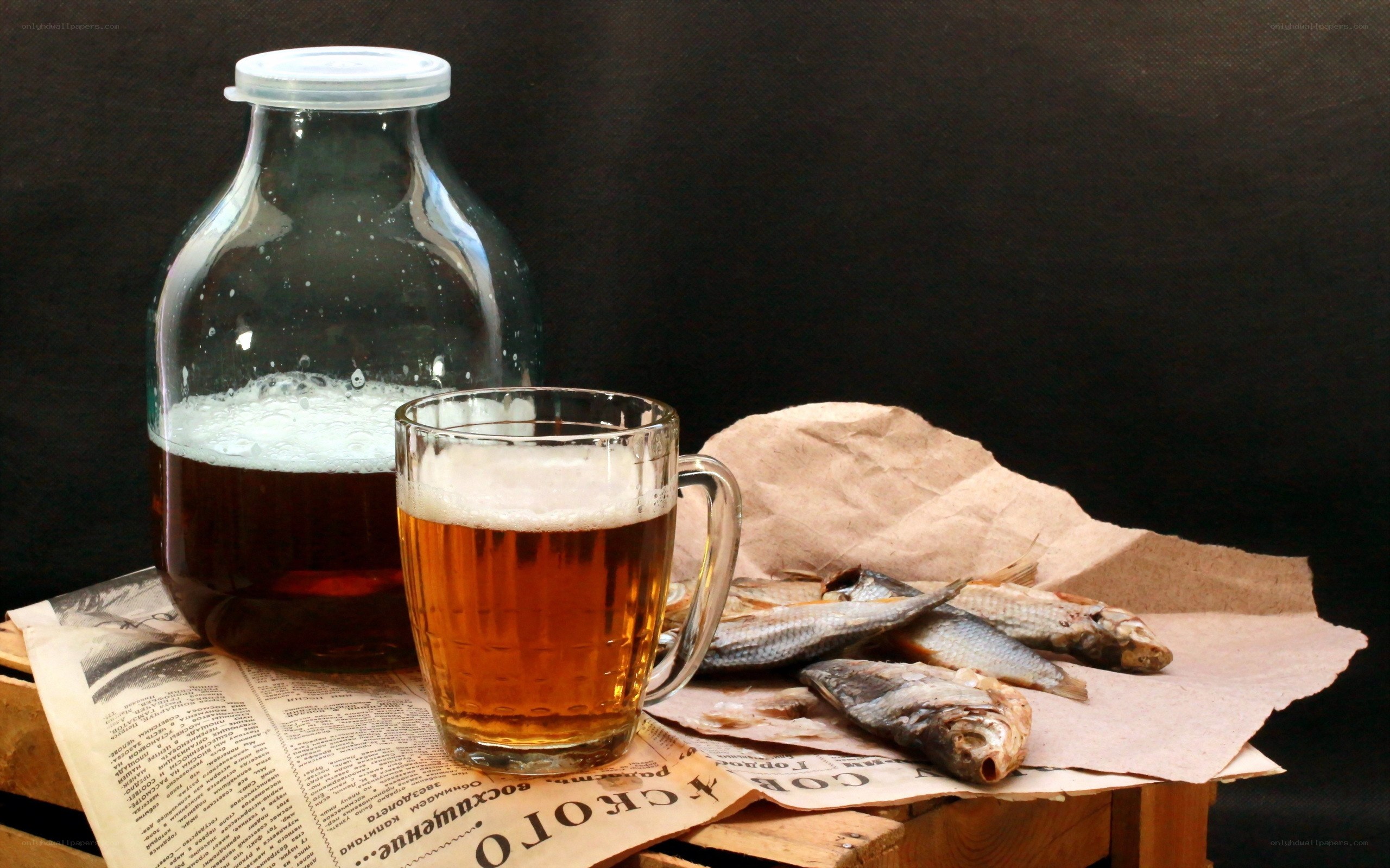 Beer and dried fish on newspaper