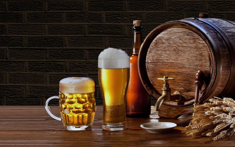 Beer glasses and barrel on wood
