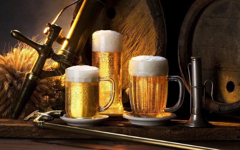 Beer glasses with foam and barrel