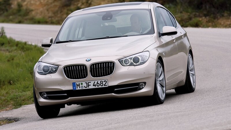 Beige BMW driving on road