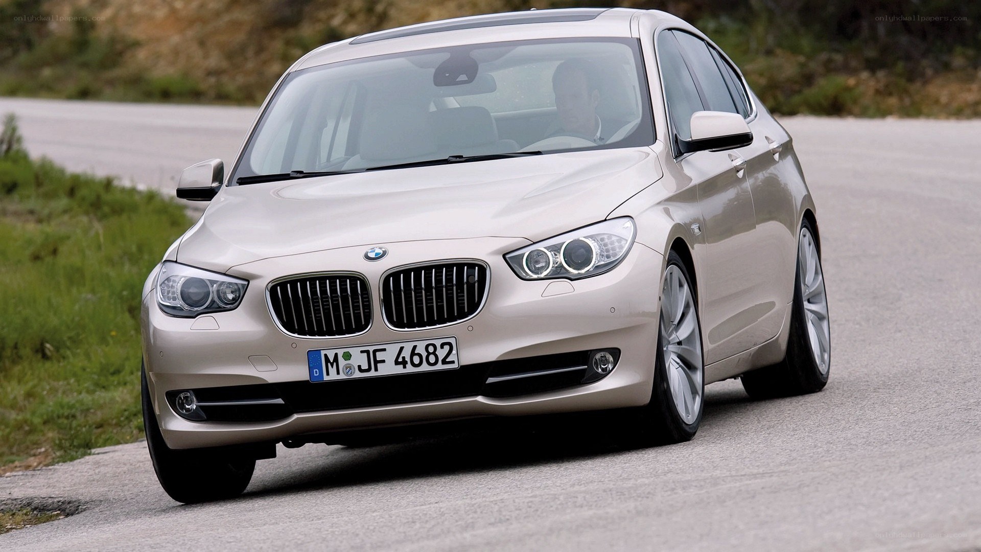 Beige BMW driving on road