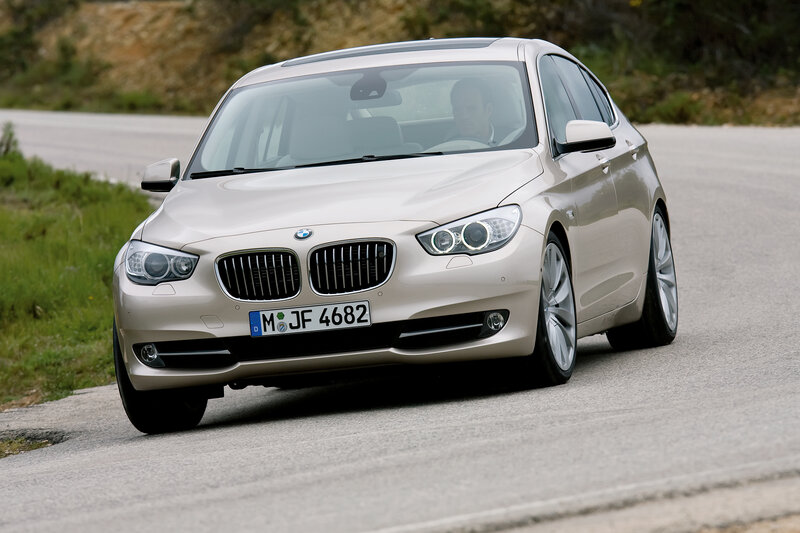 Beige BMW driving on road