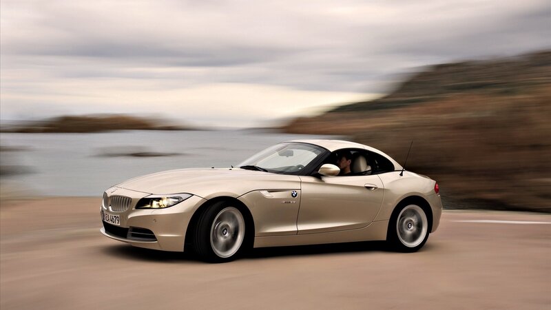 Beige BMW Z4 driving on coastal road