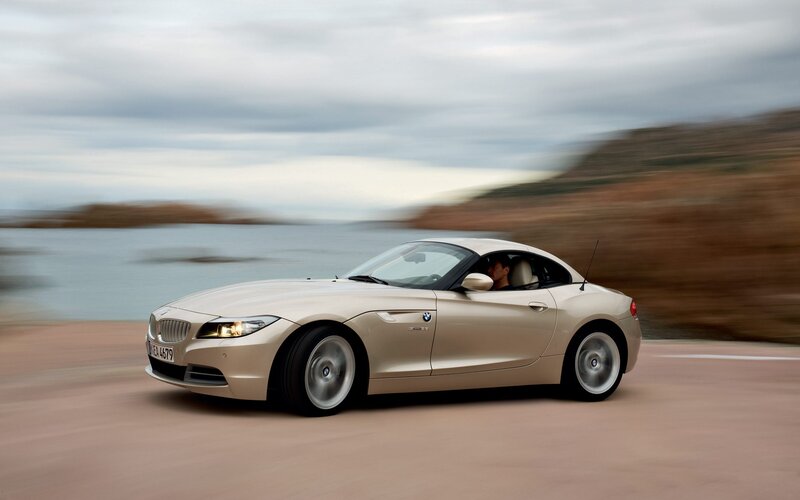 Beige BMW Z4 driving on coastal road