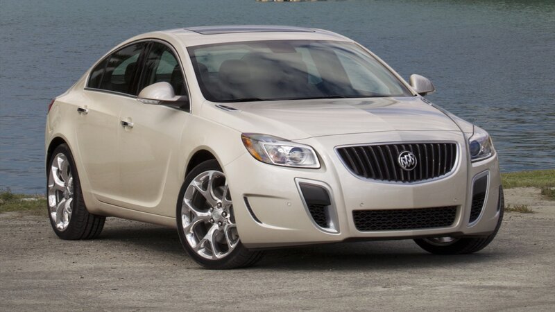 beige buick sedan by water